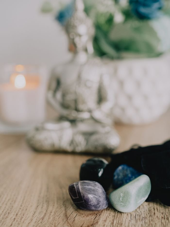 Serene Zen setup with healing crystals and a candle on a wooden table, promoting tranquility.